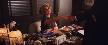 Movie still from “The Happytime Murders” (2018), directed by Brian Henson – A woman sitting at a table with a bowl of pizza; Medium shot, High angle