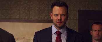 Movie still from “The Happytime Murders” (2018), directed by Brian Henson – A person wearing a suit and tie; Close Up shot, Over the shoulder angle