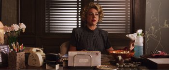 Movie still from “The Happytime Murders” (2018), directed by Brian Henson – A woman sitting at a table with a mail box; Medium shot, Low angle