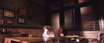 Movie still from “The Happytime Murders” (2018), directed by Brian Henson – A couple of people that are sitting at a table; Wide shot, Low angle