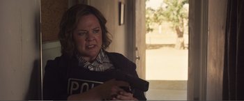 Movie still from “The Happytime Murders” (2018), directed by Brian Henson – A woman holding a gun in her hand; Medium shot, Over the shoulder angle