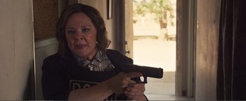 Movie still from “The Happytime Murders” (2018), directed by Brian Henson – A woman is holding a gun in her hand; Close Up shot, Over the shoulder angle