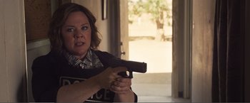 Movie still from “The Happytime Murders” (2018), directed by Brian Henson – A woman holding a gun in her hand; Medium shot, Over the shoulder angle
