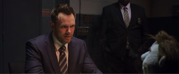 Movie still from “The Happytime Murders” (2018), directed by Brian Henson – A man in a suit and tie sitting next to another man in a suit and tie; Close Up shot, Over the shoulder angle