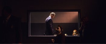 Movie still from “The Happytime Murders” (2018), directed by Brian Henson – A man standing in front of another man in a dark room; Wide shot, Over the shoulder angle