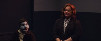 Movie still from “The Happytime Murders” (2018), directed by Brian Henson – A woman with red hair and a black jacket is standing next to another woman; Medium shot, Over the shoulder angle