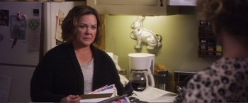 Movie still from “The Happytime Murders” (2018), directed by Brian Henson – A woman sitting at a table with papers in front of her; Medium shot, Over the shoulder angle