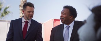 Movie still from “The Happytime Murders” (2018), directed by Brian Henson – Two men in suits standing next to each other; Close Up shot, Over the shoulder angle