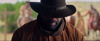 Movie still from “The Harder They Fall” (2021), directed by Jeymes Samuel – A person wearing a hat; Close Up shot, Low angle