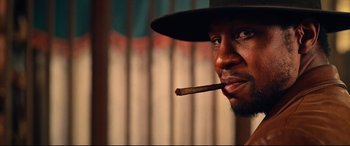 Movie still from “The Harder They Fall” (2021), directed by Jeymes Samuel – A person with a cigar in his mouth; Close Up shot, Low angle