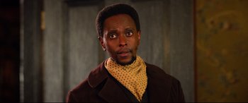 Movie still from “The Harder They Fall” (2021), directed by Jeymes Samuel – A person wearing a neck scarf; Close Up shot, Low angle