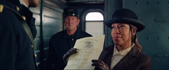 Movie still from “The Harder They Fall” (2021), directed by Jeymes Samuel – A man and a woman holding an old document; Medium shot, Low angle