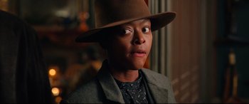 Movie still from “The Harder They Fall” (2021), directed by Jeymes Samuel – A man wearing a brown hat and a suit; Close Up shot, Over the shoulder angle