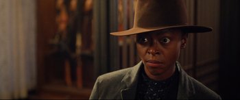 Movie still from “The Harder They Fall” (2021), directed by Jeymes Samuel – A person wearing a hat and a jacket; Close Up shot, Over the shoulder angle