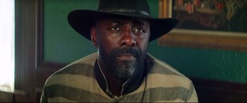 Movie still from “The Harder They Fall” (2021), directed by Jeymes Samuel – A person wearing a hat; Close Up shot, Low angle