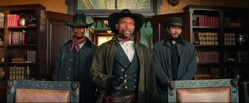 Movie still from “The Harder They Fall” (2021), directed by Jeymes Samuel – A group of men standing next to each other wearing hats; Medium shot, Low angle
