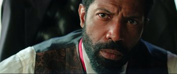 Movie still from “The Harder They Fall” (2021), directed by Jeymes Samuel – A person with a beard; Close Up shot, Over the shoulder angle