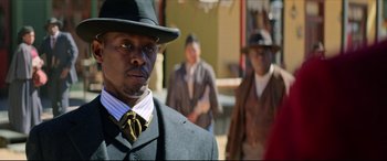 Movie still from “The Harder They Fall” (2021), directed by Jeymes Samuel – A man wearing a suit and a hat; Close Up shot, Over the shoulder angle