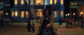 Movie still from “The Harder They Fall” (2021), directed by Jeymes Samuel – A woman in a top hat riding on a horse; Medium shot, Low angle