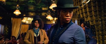 Movie still from “The Harder They Fall” (2021), directed by Jeymes Samuel – A woman in a hat is standing next to another woman in a hat; Close Up shot, Low angle