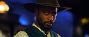 Movie still from “The Harder They Fall” (2021), directed by Jeymes Samuel – A person wearing a hat; Close Up shot, Low angle