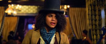 Movie still from “The Harder They Fall” (2021), directed by Jeymes Samuel – A woman wearing a top hat and a neck scarf; Close Up shot, Low angle
