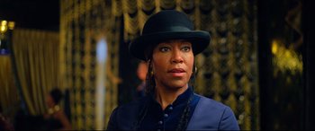 Movie still from “The Harder They Fall” (2021), directed by Jeymes Samuel – A woman wearing a black hat and a blue jacket; Close Up shot, Over the shoulder angle