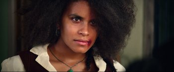 Movie still from “The Harder They Fall” (2021), directed by Jeymes Samuel – A young woman with a large black afro; Close Up shot, Low angle