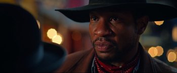 Movie still from “The Harder They Fall” (2021), directed by Jeymes Samuel – A person wearing a hat; Close Up shot, Low angle