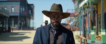 Movie still from “The Harder They Fall” (2021), directed by Jeymes Samuel – A man with a beard wearing a brown hat; Close Up shot, Low angle