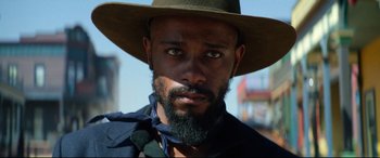 Movie still from “The Harder They Fall” (2021), directed by Jeymes Samuel – A person wearing a hat; Close Up shot, Low angle