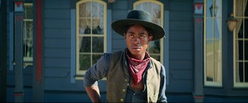 Movie still from “The Harder They Fall” (2021), directed by Jeymes Samuel – A man wearing a cowboy hat and a vest; Close Up shot, Low angle