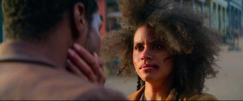 Movie still from “The Harder They Fall” (2021), directed by Jeymes Samuel – A woman with a large afro is looking into the mirror; Close Up shot, Over the shoulder angle