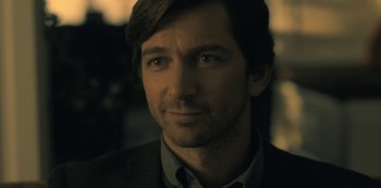 Movie still from “The Haunting of Hill House” (2018), directed by Mike Flanagan – A person wearing a suit and tie; Close Up shot, Over the shoulder angle