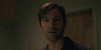 Movie still from “The Haunting of Hill House” (2018), directed by Mike Flanagan – A person wearing a shirt; Close Up shot, Low angle