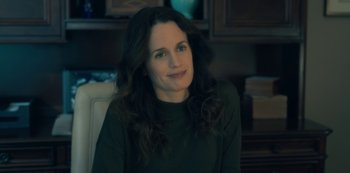 Movie still from “The Haunting of Hill House” (2018), directed by Mike Flanagan – A woman sitting in a chair smiling for the camera; Close Up shot, Over the shoulder angle