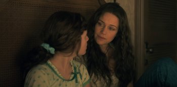 Movie still from “The Haunting of Hill House” (2018), directed by Mike Flanagan – A young girl looking at another young girl in front of a mirror; Close Up shot, Over the shoulder angle