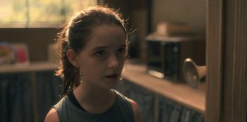 Movie still from “The Haunting of Hill House” (2018), directed by Mike Flanagan – A young girl is looking into the distance; Close Up shot, Over the shoulder angle