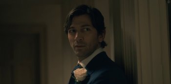 Movie still from “The Haunting of Hill House” (2018), directed by Mike Flanagan – A person wearing a suit and tie; Close Up shot, Over the shoulder angle