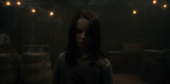Movie still from “The Haunting of Hill House” (2018), directed by Mike Flanagan – A young girl in a dark room looking sad; Close Up shot, Over the shoulder angle