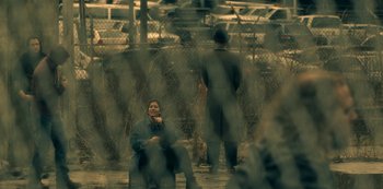 Movie still from “The Haunting of Hill House” (2018), directed by Mike Flanagan – A woman sitting on a chair in front of a fence; Wide shot, Over the shoulder angle