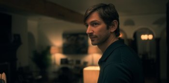 Movie still from “The Haunting of Hill House” (2018), directed by Mike Flanagan – A person wearing a black shirt; Close Up shot, Over the shoulder angle