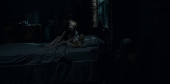 Movie still from “The Haunting of Hill House” (2018), directed by Mike Flanagan – A girl sitting on a bed next to a teddy bear; Wide shot, High angle