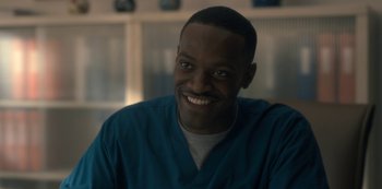 Movie still from “The Haunting of Hill House” (2018), directed by Mike Flanagan – A man in a blue shirt smiling for the camera; Close Up shot, Over the shoulder angle