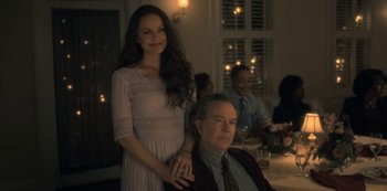 Movie still from “The Haunting of Hill House” (2018), directed by Mike Flanagan – A man and a woman posing for a picture; Medium shot, Over the shoulder angle