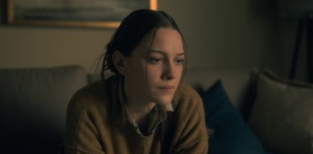 Movie still from “The Haunting of Hill House” (2018), directed by Mike Flanagan – A woman sitting on a couch looking at the camera; Close Up shot, Over the shoulder angle