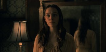 Movie still from “The Haunting of Hill House” (2018), directed by Mike Flanagan – A woman with long dark hair standing in front of a mirror; Close Up shot, Over the shoulder angle