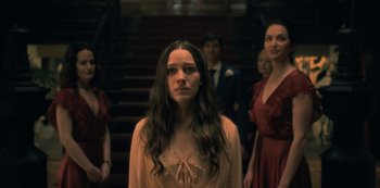 Movie still from “The Haunting of Hill House” (2018), directed by Mike Flanagan – A group of people standing in front of a staircase; Medium shot, Over the shoulder angle