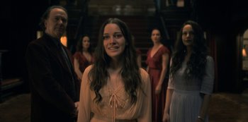 Movie still from “The Haunting of Hill House” (2018), directed by Mike Flanagan – A group of people standing in a room; Medium shot, Over the shoulder angle