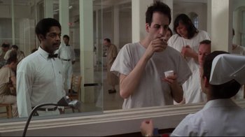 Movie still from “One Flew Over the Cuckoo's Nest” (1975), directed by Milos Forman – A man is taking a picture of himself in the mirror; Medium shot, Over the shoulder angle